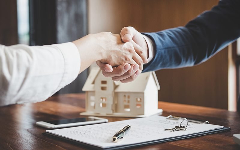 Real estate agent and customers shaking hands together celebrating finished contract after about home insurance and investment loan, handshake and successful deal.
